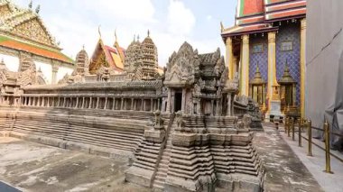 Wat Phra Kaew 'in Bangkok' taki süslü yapılarının detaylı bir görüntüsü, doğal gün ışığı altında karmaşık oymalar ve canlı renkler sergiliyor.