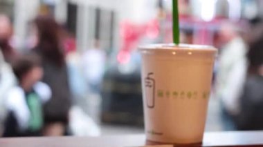 Kalabalık sokak sahnesi ve odaklı bir içki.