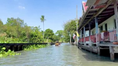 Bir tekne Bangkok 'ta bir kanalda geziniyor.