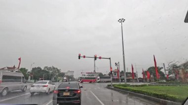 Araçlar ıslak ve yoğun bir kavşaktan geçiyor.