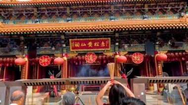 Hong Kong tapınağında tütsü ikram eden ziyaretçiler.