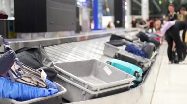 Havaalanı taşıma bandından çantaları alan yolcular