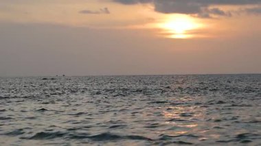 Karon Sahili, Phuket, Tayland 'da okyanus dalgaları üzerinde huzurlu bir gün batımı