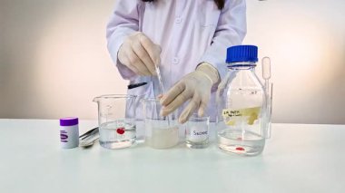 Bilim adamı kontrollü bir laboratuvar ortamında potasyum permanganat kullanarak renk değiştiren bir kimyasal deney yürütüyor.