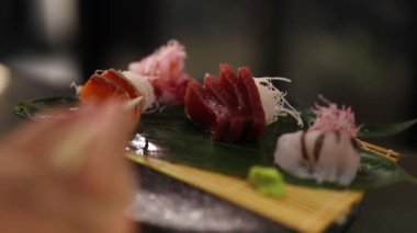 Tabaktan elle suşi parçaları topluyorum.