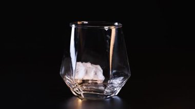 Buz küpleri kadehe sırayla düşer.