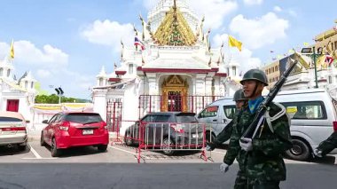 Üniformalı askerler Bangkok, Tayland 'daki Şehir Sütun Tapınağı' nın önünden gündüz vakti geçerek tören hassasiyetini sergiliyorlar.