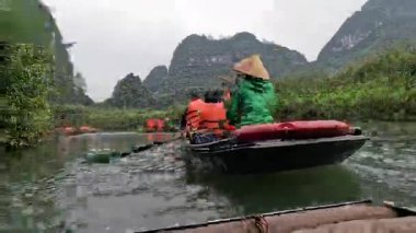 Resimli bir manzarada kürek çeken turistler