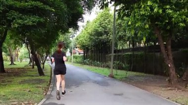 Yeşillik bir bahçe yolunda koşan biri