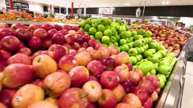 Süpermarkette düzgünce düzenlenmiş çeşitli elmalar