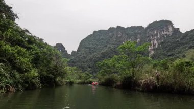 Huzurlu bir nehir manzarası boyunca seyahat eden tekne.