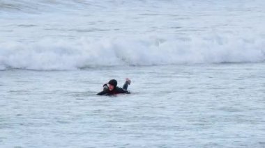 Okyanusta sörf yapan bir sörfçü.