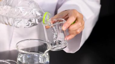 Bilim adamı kuru buzla beherin içine su döküyor.