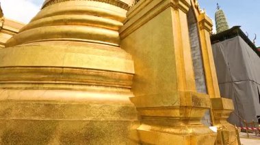 Wat Phra Kaew 'deki altın pagoda' nın dinamik bir görüntüsü, Bangkok, Tayland 'da gün ışığında karmaşık mimarisini gözler önüne seriyor.