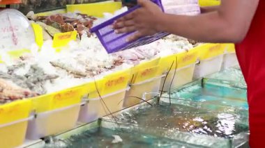 Pazarda deniz ürünlerinin üzerine buz yayılıyor.