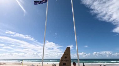 Güneşli bir sahilde dalgalanan bayraklar