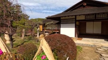 Bahçeli bir Japon evinin huzurlu manzarası.