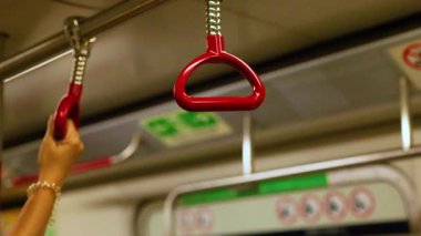 Bir el, metro sapını sıkıca kavrar.