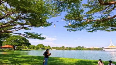 İnsanlar dingin bir göletin kenarında doğanın tadını çıkarıyor.