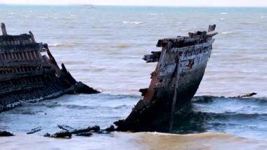 Dalgalar çürüyen bir gemi enkazına çarpar