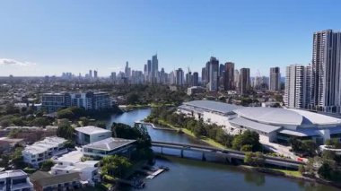 İnsansız hava aracı görüntüleri, açık mavi gökyüzünün altında, şehir mimarisi ve doğal güzellikleri gösteren manzaralı Altın Sahil siluetini ve rıhtımını yakalıyor.