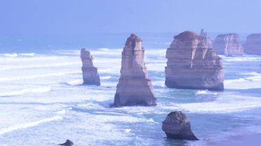 12 havarinin sakin manzarası Büyük Okyanus Yolu boyunca kayalık oluşumlar halinde yumuşak gün ışığında hafif dalgalarla yakalanır.