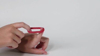 Kızıl bir saç teli takıyor.