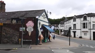 İnsanlar dükkanların ve binaların yanında yürüyorlar