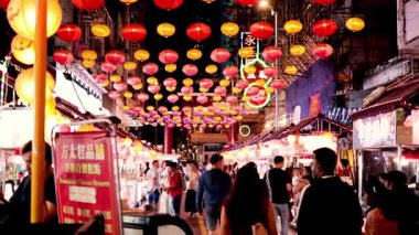 Canlı fenerler hareketli bir gece pazarı sahnesini aydınlatıyor.