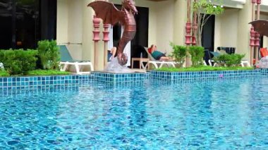 Tayland, Krabi 'de sakin bir havuz manzarası. Huzurlu bir yüzme havuzu ve güneşli gökyüzünün altında misafir ağırlama.