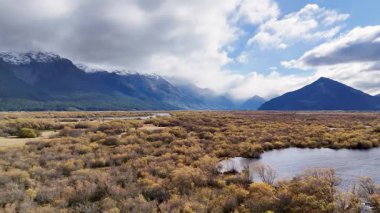 Glenorchy 'nin dağlarının ve nehrinin dinamik bulutlar ve güneş ışığı altında 13 saniyelik bir videoda sakin bir görüntüsü.