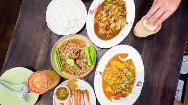 Çeşitli geleneksel Tayland yemekleri servis ediliyor.