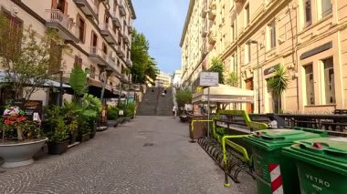 Merdivenleri ve yeşilliği olan sessiz bir sokak.