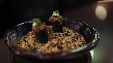 Tabaktan yemek çubuklarıyla elle suşi topluyorum.