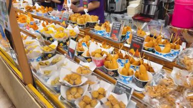 Bangkok, Tayland - 15 Aralık 2024: Kalabalık bir pazarda çeşitli kızarmış atıştırmalıklar