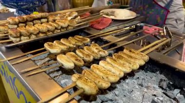 Pazar yerinde mangal kömürü üzerinde ızgara yapan muzlar