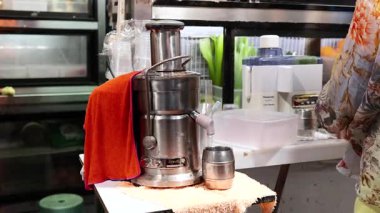 Meyve sıkacağı ile meyve suyu hazırlayan kişi