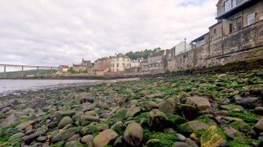 Bir sahil kasabası boyunca yosun kaplı kayalar
