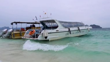 Turistler tekneden kumsala iniyor.