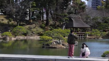 İki insan huzurlu bir bahçe ortamının tadını çıkarıyor.