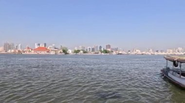 Bir tekne şehrin arka planında suda hareket eder.