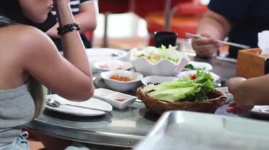 Kore mangal restoranında yemek paylaşan arkadaşlar.