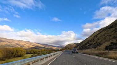 Wanaka 'dan sakin bir sürüş, canlı manzaralar ve temiz gökyüzü, düz kamera hareketleri ve doğal ışıklandırmayla yakalanmış.