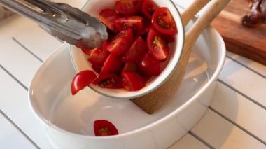 Kavanozda dilimlenmiş domates tutan maşalar