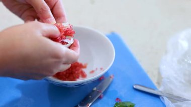 Mutfak tezgahındaki bir kaseye limon hamuru döken eller.