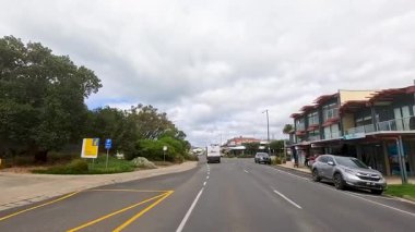 Great Ocean Yolu 'ndaki sahil kasabasında 25 saniyelik bir sürüş. Canlı sokak hayatı ve yemyeşil yaşam sergileniyor.