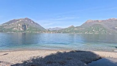 Serene lake with distant mountains under blue sky