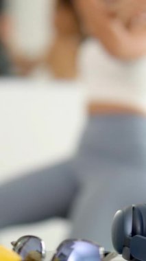 Antrenman kıyafetli bir kadın parlak bir spor salonunda muz alıyor.