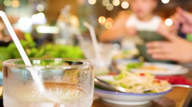 Restoranlar Bangkok 'un hareketli bir restoranında keyifli bir yemeğin tadını çıkarıyorlar. Ilık ışık ve bulanık hareket enerjik bir atmosfer yaratır.