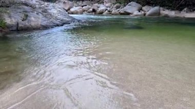 Berrak su, Mossman Vadisi 'ndeki kayaların üzerinden yavaşça akar. Etrafı yemyeşil yağmur ormanlarıyla çevrilidir. Yumuşak ışık, dinginliği ve doğal atmosferi arttırır.